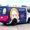ผลงานติดตั้งสติ๊กเกอร์รถ Roadshow บนรถตู้สื่อโฆษณาเคลื่อนที่ สร้างการรับรู้แบรนด์ครอบคลุมทั้งด้านข้างและด้านหลัง สติ๊กเกอร์รถ Roadshow ติดรถตู้โฆษณา Money Expo แบบครึ่งคันถึงท้ายรถ มุมมอง 3/4 แสดงดีไซน์กราฟิกสดใส